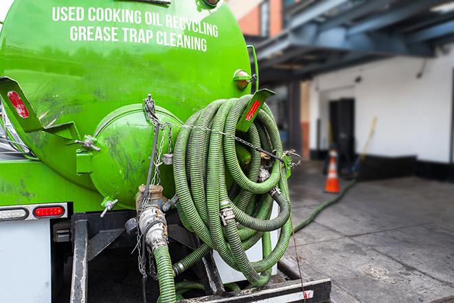 a grease trap being pumped by a sanitation technician in Fredericksburg VA